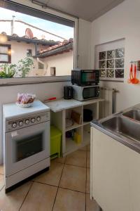 佛罗伦萨Casa Quaratesi的厨房配有水槽和炉灶 顶部烤箱