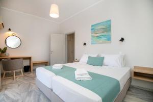 罗希姆诺Mardinik Hotel Apartments的卧室配有带毛巾的大型白色床