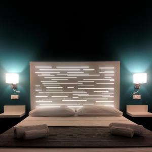 巴勒莫B&B Angolo83 Palermo centro的卧室配有一张带两个灯的大白色床