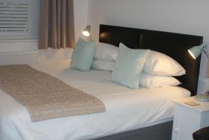 奥尔德堡蒂拉住宿加早餐旅馆的一张带白色枕头和黑色床头板的床