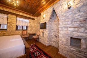 培拉特Berati Castle Hotel的一间石墙卧室和一张位于客房内的床
