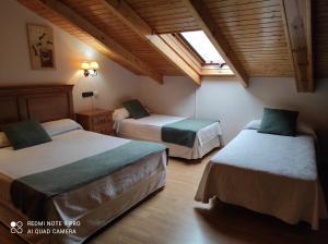 罗德里戈城太阳门旅馆的一间卧室设有两张床和窗户。