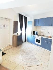 格拉茨Apartmenthaus beim LKH Graz的厨房配有蓝色橱柜,铺有瓷砖地板。