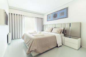 维亚纳堡River Town View - Luxury Apartment with Jacuzzi on Terrace的一间白色卧室,配有床和电视