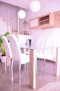 瓜迪亚纳河畔桑卢卡尔La Tinajita的一间带桌子和白色椅子的用餐室