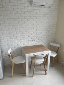 切尔卡瑟Лучшие апартаменты для размещения с детьми возле Днепра, центр в пешей доступности的一张木桌和两把椅子以及白色的墙壁