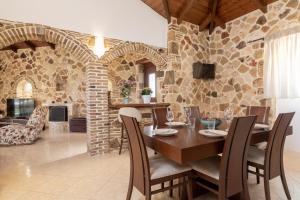 MouzákionVilla La Isla with Private Pool的一间设有桌子和石墙的用餐室