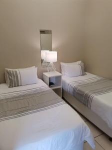 斯特尔拜Muir Holiday Apartments的一间卧室配有两张床和一盏灯。