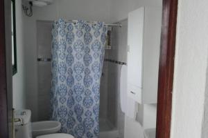 SabinosaCasita Abuela Rosa的浴室配有蓝色的浴帘和卫生间