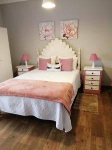 格兰杜拉Casa Vaz的卧室配有带粉红色枕头的大型白色床