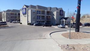埃尔帕索InTown Suites Extended Stay El Paso TX的享有公寓大楼的街景,设有停车位