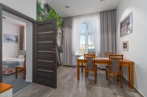 热舒夫Nasze Kamienice Apartament Express Rzeszów Główny的一间带桌椅的用餐室和一间卧室