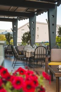 波德戈里察克托酒店的庭院配有桌椅和红色鲜花