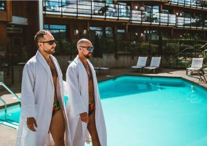 布伦特伍德湾布伦特伍德海湾度假酒店及Spa的两个男人站在游泳池旁边