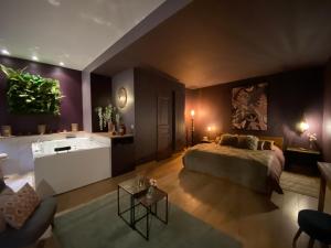 Fleury-en-BièreLa Planque - Chambres avec Jacuzzi的卧室配有床和浴缸