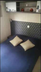 卢贝新城Mobilhomme bungalow 6 personnes villeneuve loubet marina baie des anges的一间卧室配有蓝色的床和两个枕头