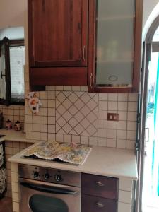 卡夏La Bomboniera Cascia的厨房配有木制橱柜和炉灶烤箱。