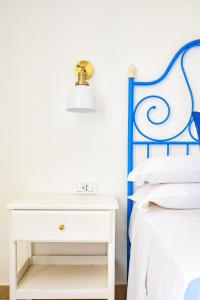 加埃塔Volver B&B的卧室配有白色床头柜,毗邻一张床
