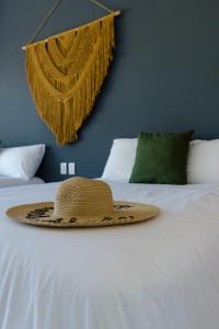 奥尔沃克斯岛Sanyama Holbox的坐在床上的草帽