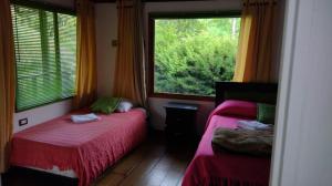 萨兰托Hotel Selva Verde的一间卧室设有两张床和大窗户