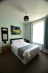 海斯廷斯格罗夫纳宾馆的卧室配有一张床,墙上挂着一辆黄色汽车