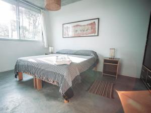 拉帕洛马Altos de la Serena Apart Hotel的一间卧室配有一张床、一张桌子和一个窗户。