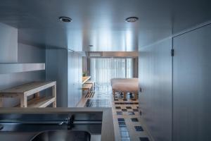 名古屋Seven Stories的一个带水槽的厨房和一张位于客房内的床