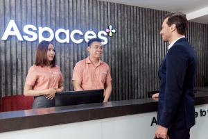 河内Aspaces Serviced Apartments - Vinhomes West Point的两个男人和一个女人站在电脑前