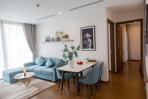 河内Aspaces Serviced Apartments - Vinhomes West Point的客厅配有蓝色的沙发和桌子