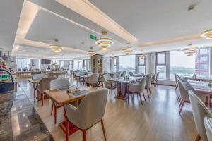 南京南京九龙湖金陵嘉辰酒店（南京南站店）的餐厅设有桌椅和窗户。