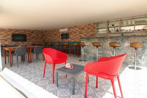 达利安Dna Hotel Dalyan的一间设有红色椅子的餐厅和一间酒吧