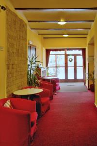 哈拉霍夫哈拉霍夫酒店的一间设有红色椅子和桌子的等候室