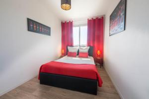 克莱蒙费朗Coca gare的一间卧室配有一张带红色床单的床和一扇窗户。