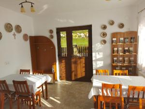 SînnicoarăPensiunea Albina的一间设有两张桌子和椅子的用餐室以及一扇门