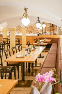Ossig桑恩霍夫酒店的餐厅设有木桌和椅子及灯