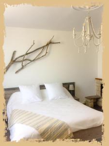 图卢兹La Bulle dans le Palmier的卧室配有白色的床和吊灯。