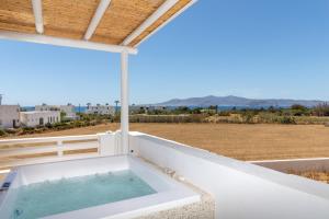 MaragkasVilla Gold & White的阳台设有浴缸,享有田野美景。