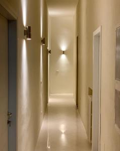 莱切HABITARE Lecce & Salento的一条带白色门的走廊,上面有灯