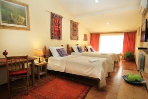 埃里温丝绸之路酒店的酒店客房带两张床、一张桌子和一张桌子。