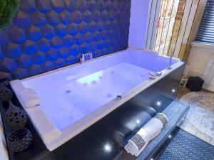 里昂HOST INN - CŒUR VIEUX LYON & SPA的带浴缸的浴室和蓝色的墙壁