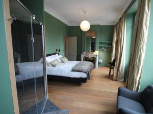 波尔多B&B L'Escapade Bordelaise - Côté Jardin的一间卧室设有绿色的墙壁、一张床和镜子