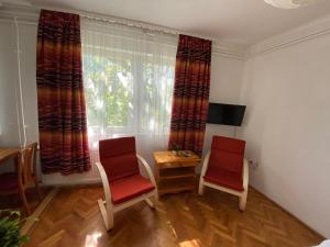 希欧福克Anonymus Vendégház的一间设有两把椅子、一张桌子和一个窗户的房间