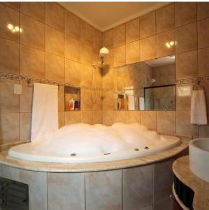 伊图佩瓦Hotel ITR-SPA的一个带镜子的浴室内的大浴缸