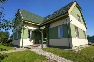 ButrynyPokoje Gościnne Butryny的绿色和白色的房子,拥有绿色的屋顶