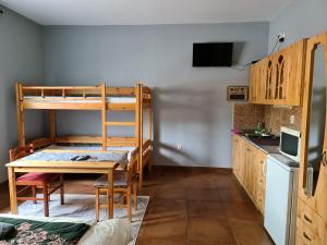 莫劳豪洛姆Amina Apartman的客房设有一张桌子和一张双层床。