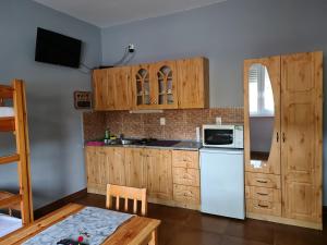 莫劳豪洛姆Amina Apartman的厨房配有木制橱柜和白色冰箱。