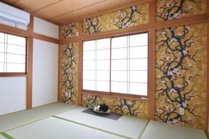 东京Sasatsuka Fleur Tachibana Hotel Apartment的客房设有窗户和花卉壁纸。