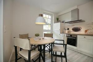 博尔滕哈根Strandvilla Scholle - Dorsch Wohnung 02的厨房配有桌椅