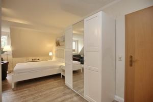 博尔滕哈根Strandvilla Krabbe Wohnung 12的卧室配有白色的床和镜子