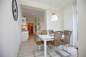 博尔滕哈根Villa Triton Wohnung 01的一间配备有白色桌椅的用餐室
